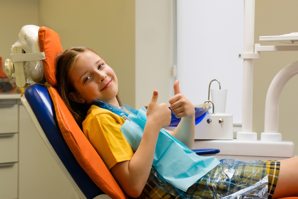 Schoolgirl,In,Good,Mood,Shows,Thumb,Up,While,Sitting,In
